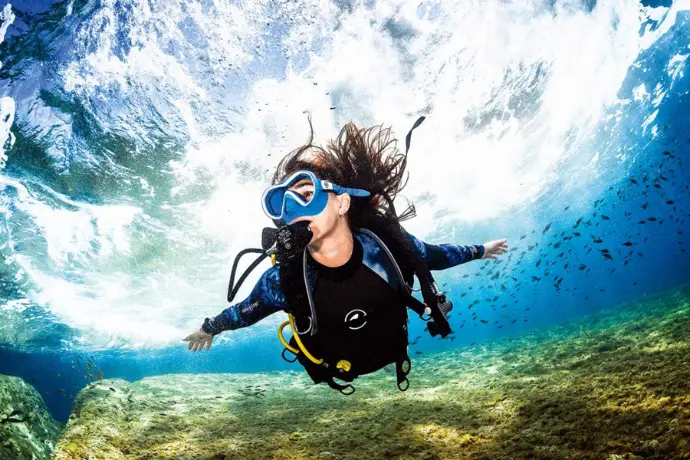 Scuba Girl diving in Blue Ocean